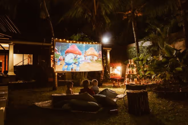 Outdoor cinema night at Muse Villas with kids, fairy lights, popcorn, and a movie under the stars.