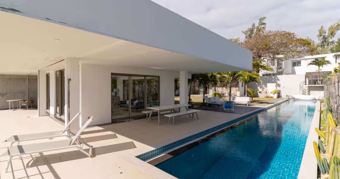 Modern outdoor patio with pool and loungers at Muse Villas