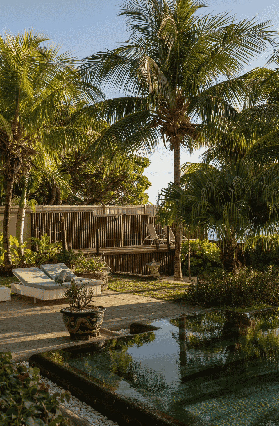 Relaxing tropical beachfront setting with lush greenery and calm sea views.
