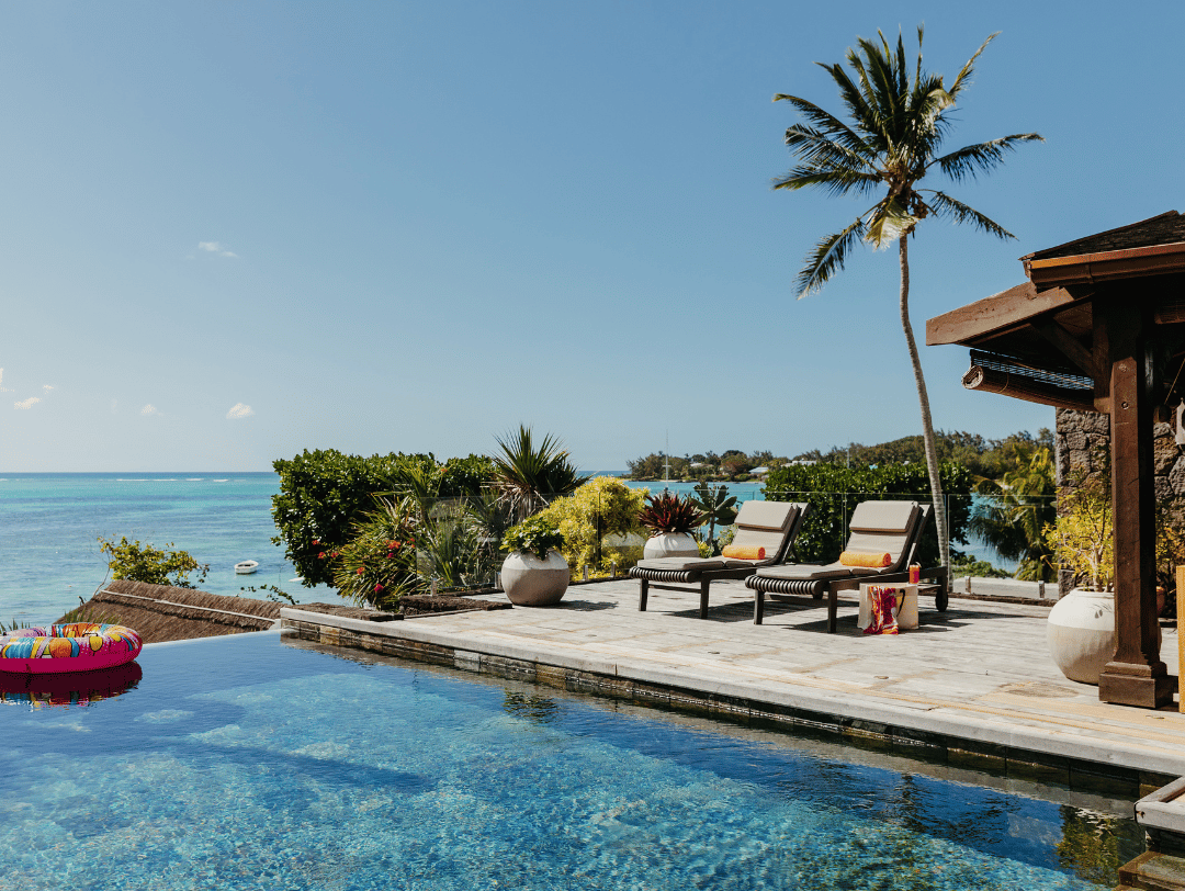 Relax by a paradise-style swimming pool at a beachfront property in Mauritius during an October summer holiday.