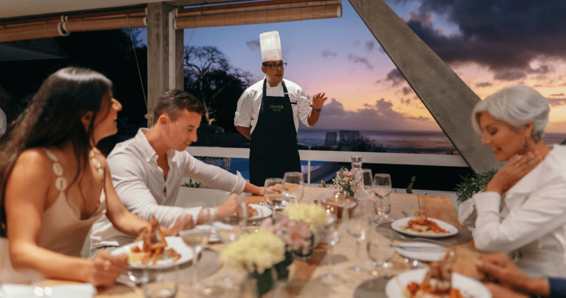 A professional private chef carefully plates a gourmet dish for guests during an exclusive in-villa dining experience.