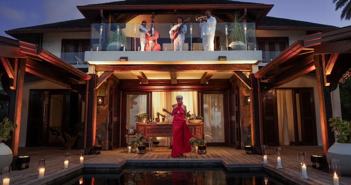 Elegant guest in a red gown dancing poolside during a New Year's Eve villa party in Mauritius