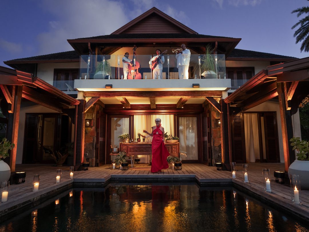 Elegant guest in a red gown dancing poolside during a New Year's Eve villa party in Mauritius