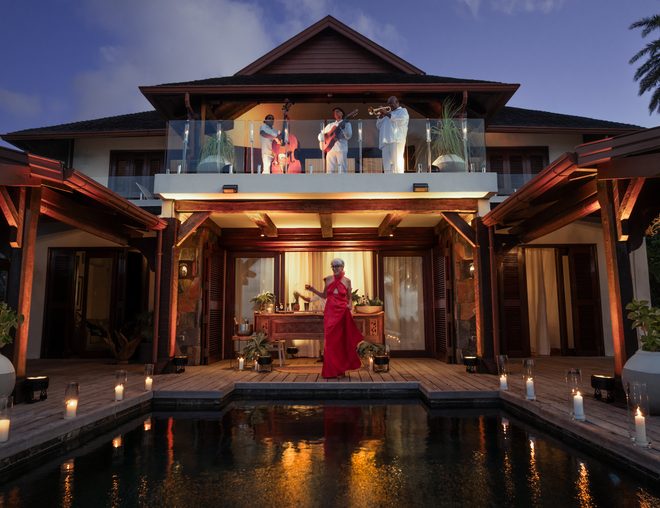 Live jazz trio performing on a villa balcony above a candlelit pool for a Mauritius NYE celebration