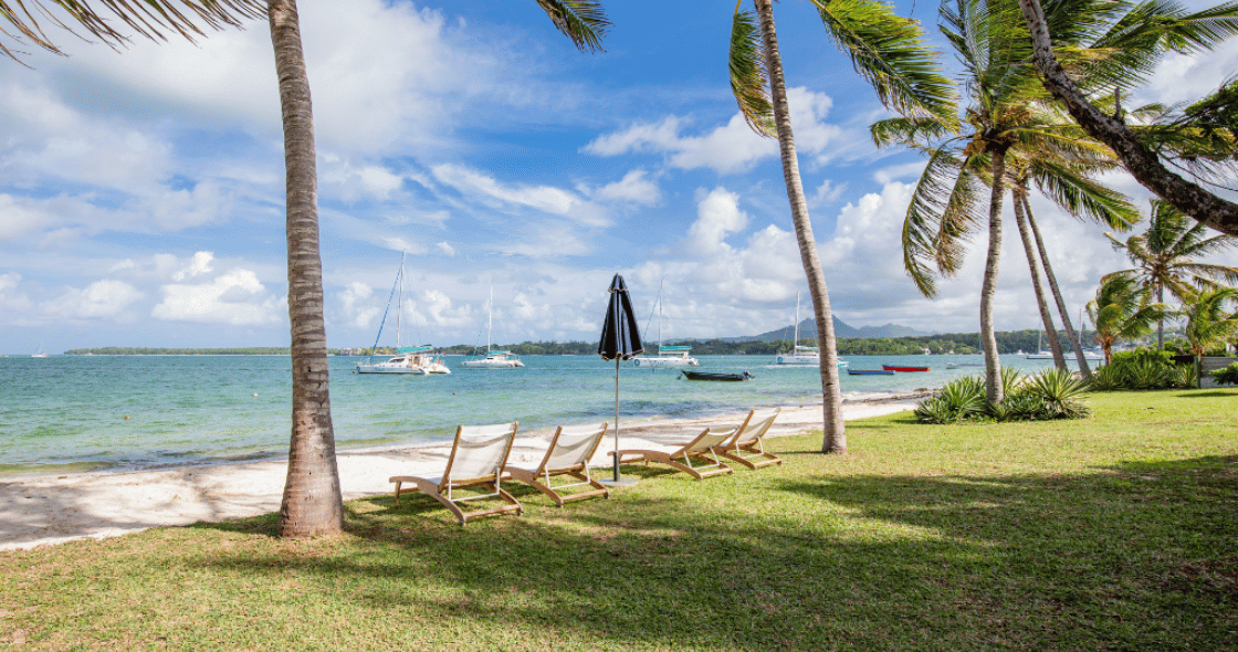 A beautiful sun-drenched Mauritian beach with warm, crystal-clear water, perfect for end-of-year celebrations.