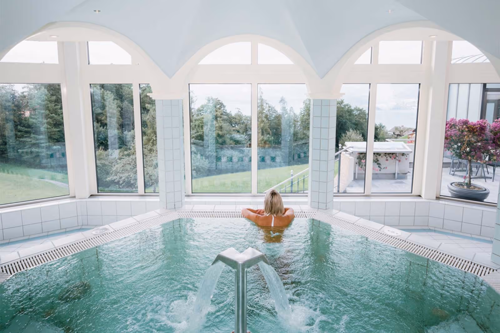 Une personne dans le jacuzzi avec vue sur les Alpes bernoises et le lac de Thoune