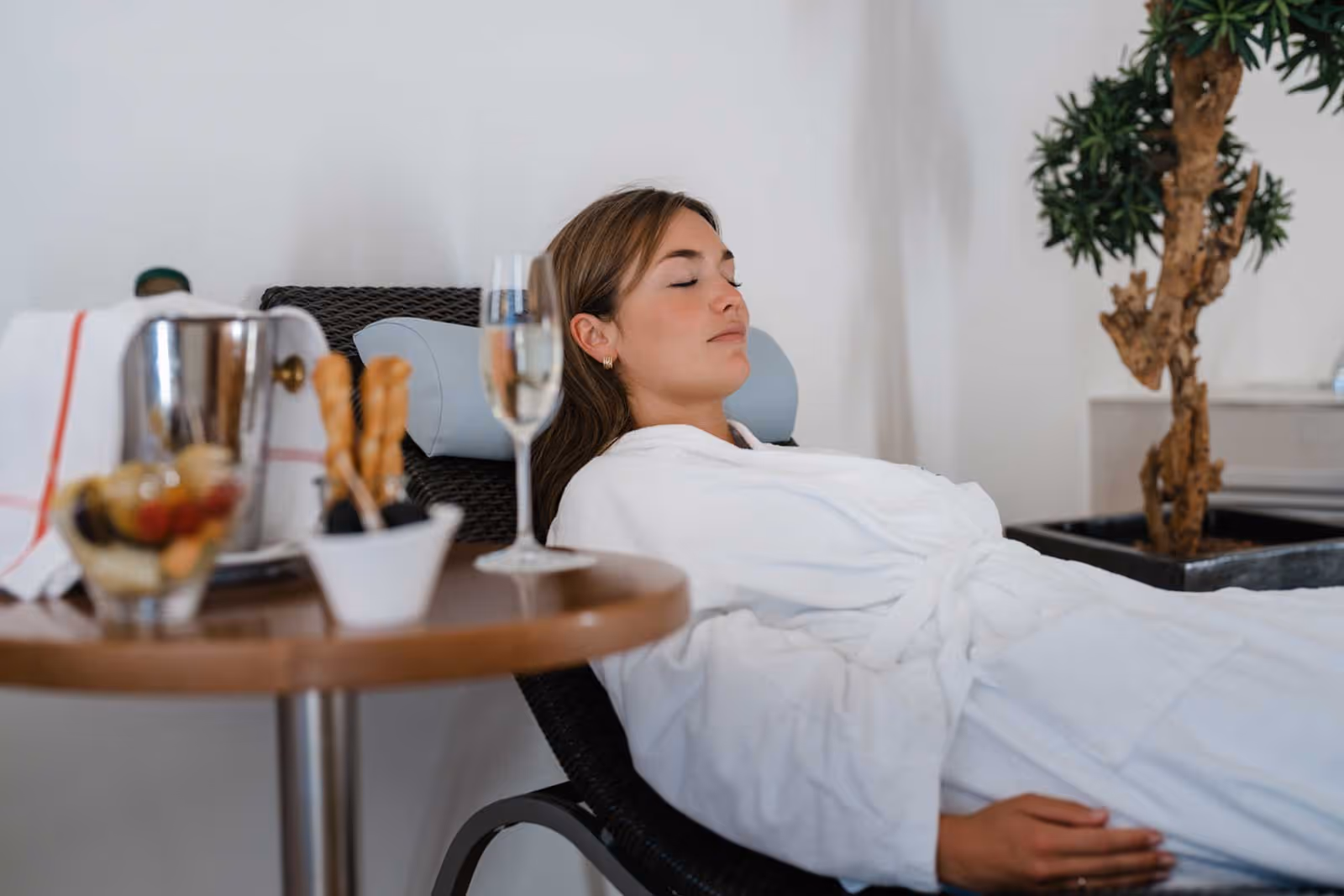 Femme sur une chaise longue avec du champagne et des fruits