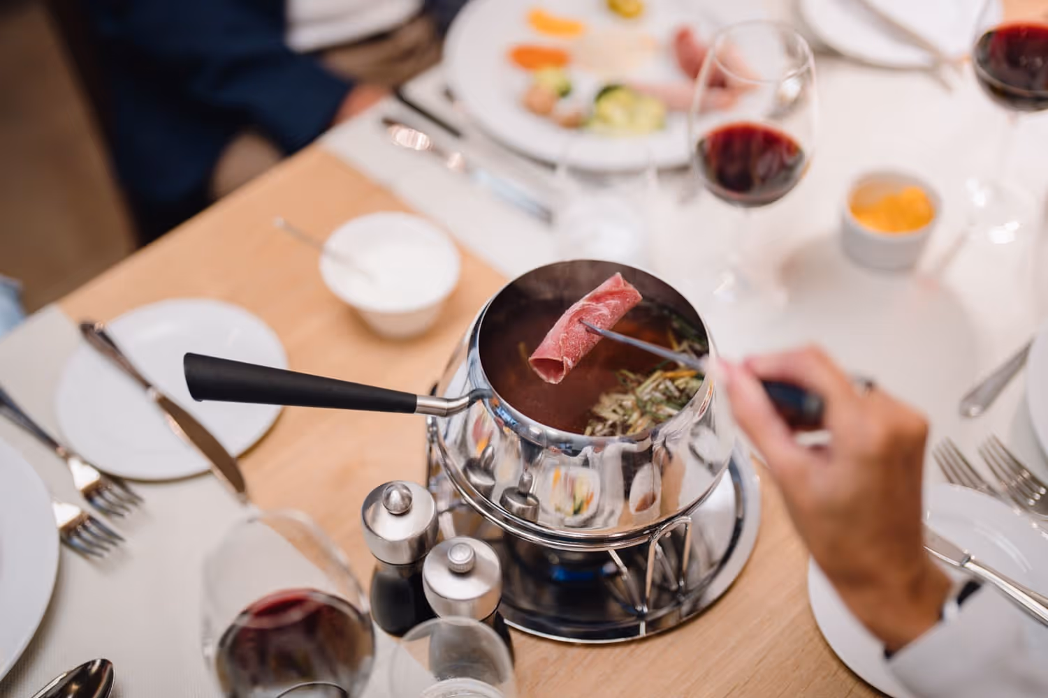 Ein Winzerfondue Caquelon auf dem Tisch 