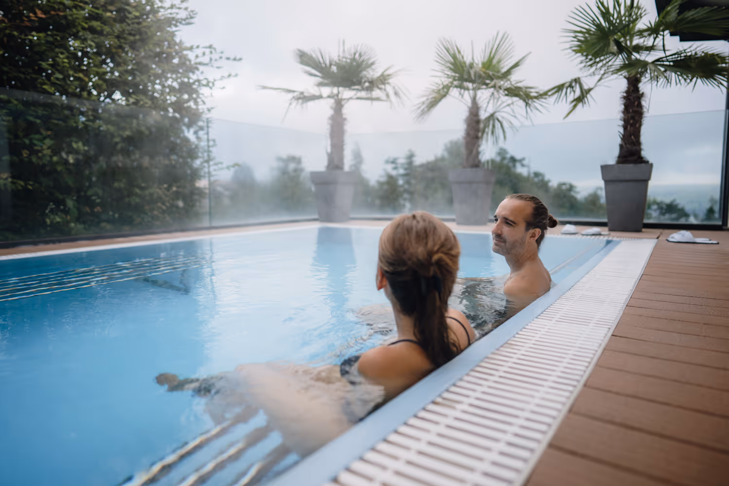 Deux personnes profitent de la vue depuis la piscine extérieure.
