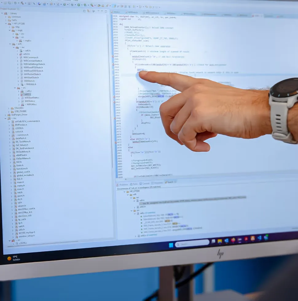 En hånd peger på en skræm med noget HTML kode på