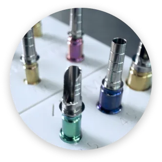 Close-up of colorful metal nozzles attached to a white base, used for a machine.