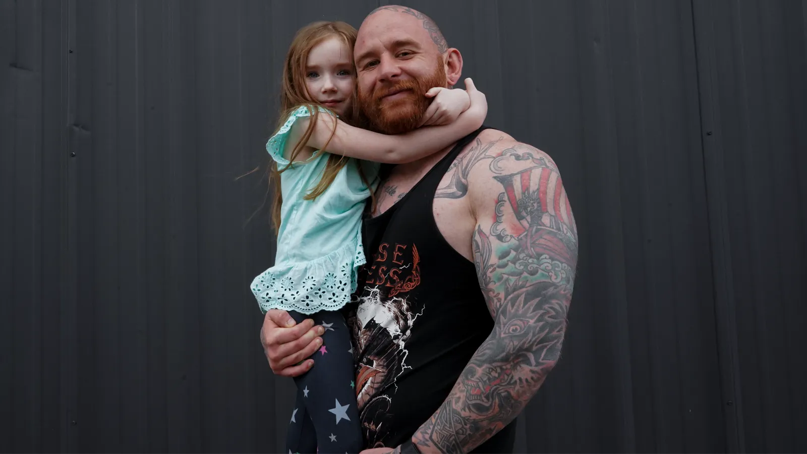 Andrew Lewis holding his daughter, who is hugging his neck