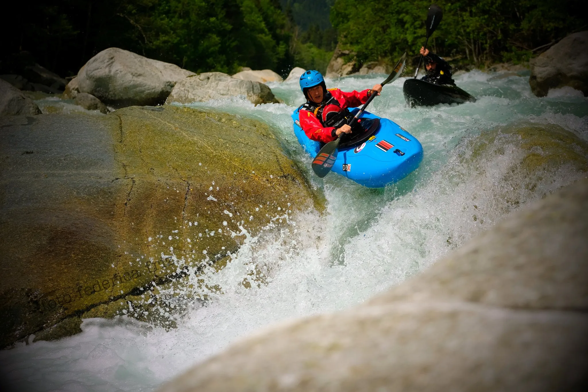 A kayaker dropping in to a slide