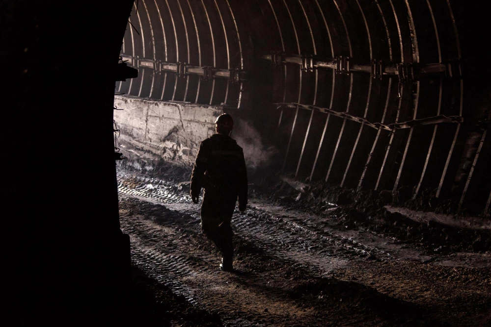 Miner walks in underground coal mining tunnel