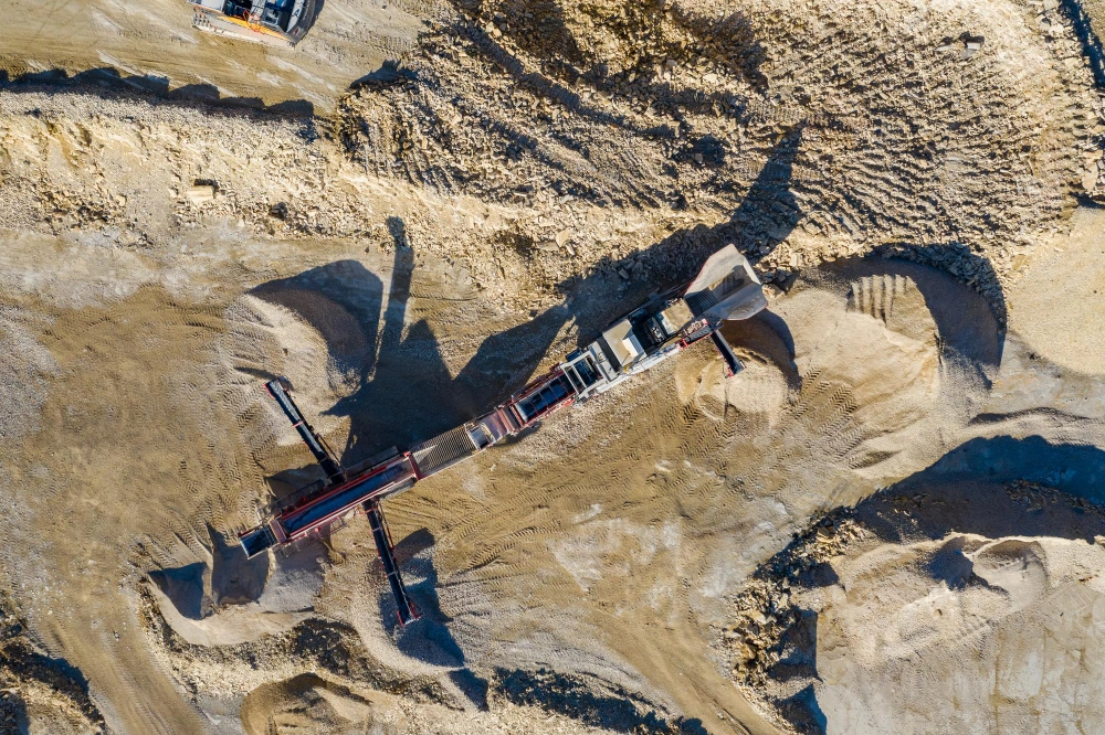A bird's eye view of a mine where a conveyor belt is transporting minerals