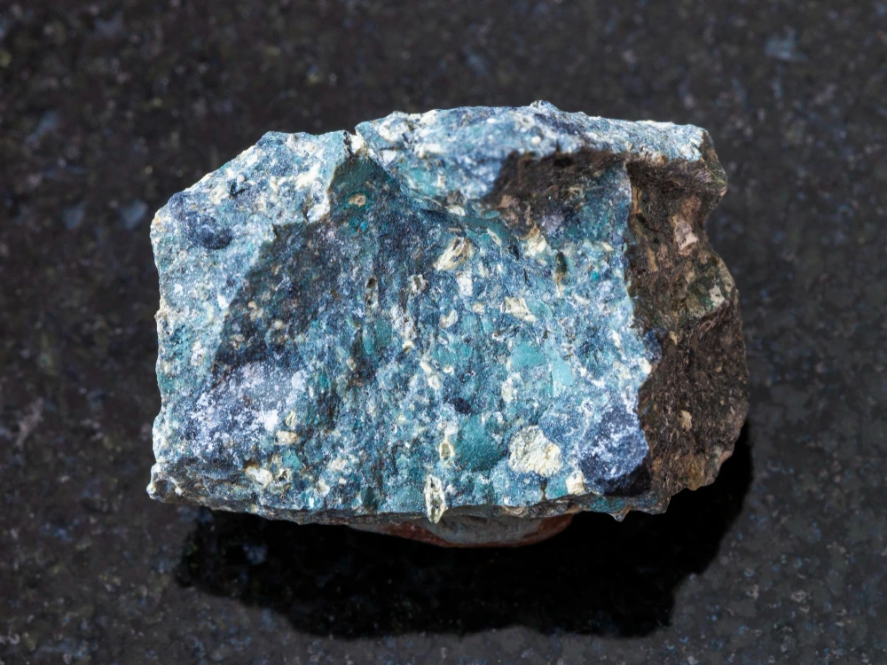 A close-up of a blue kimberlite (diamond-bearing ore) on a black background