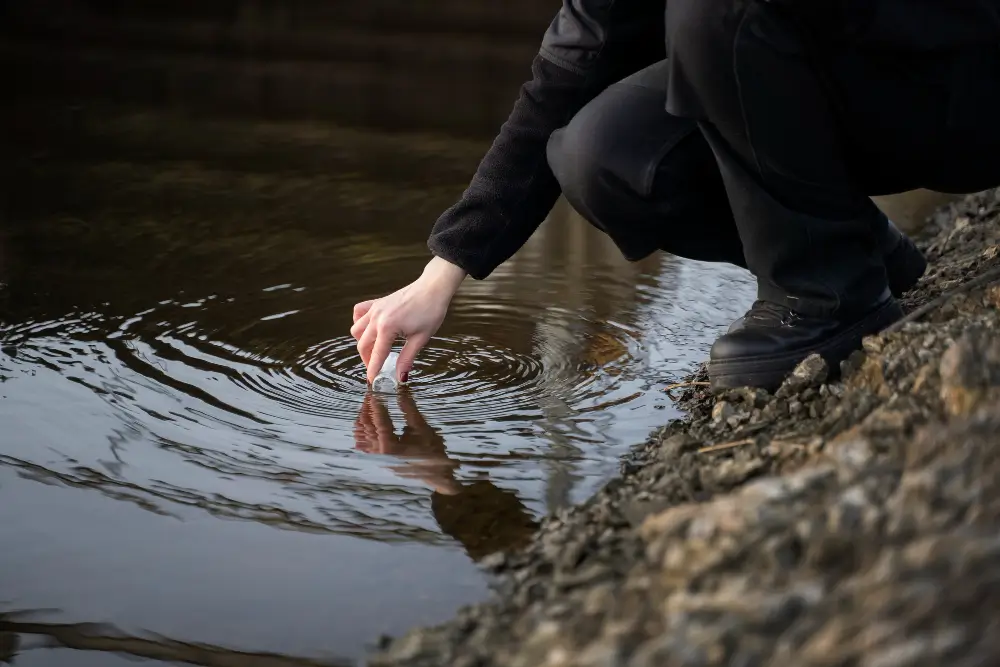 Person dressed in black draws a sample of groundwater