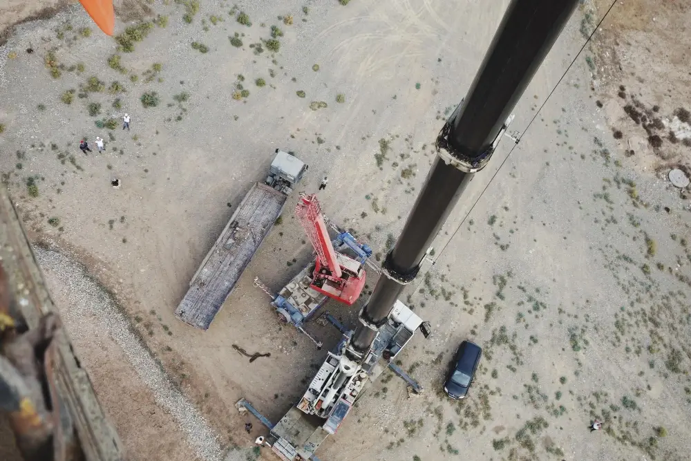 Bird's eye view of construction site where a car, truck, and rig are situated on a large sand bank