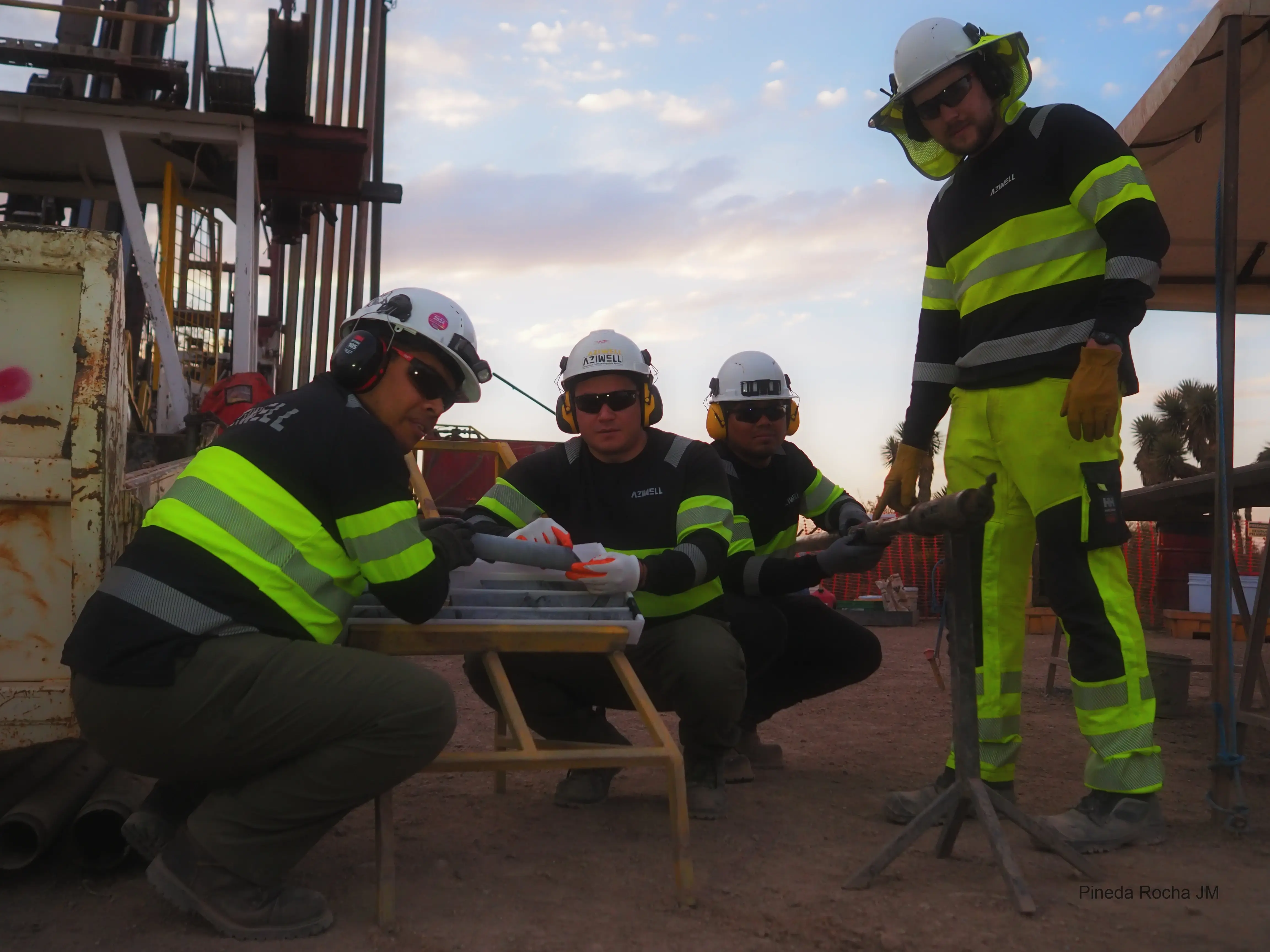 Un equipo de expertos inspeccionando muestras de núcleos de perforación en un sitio minero para el análisis de depósitos de cobre.