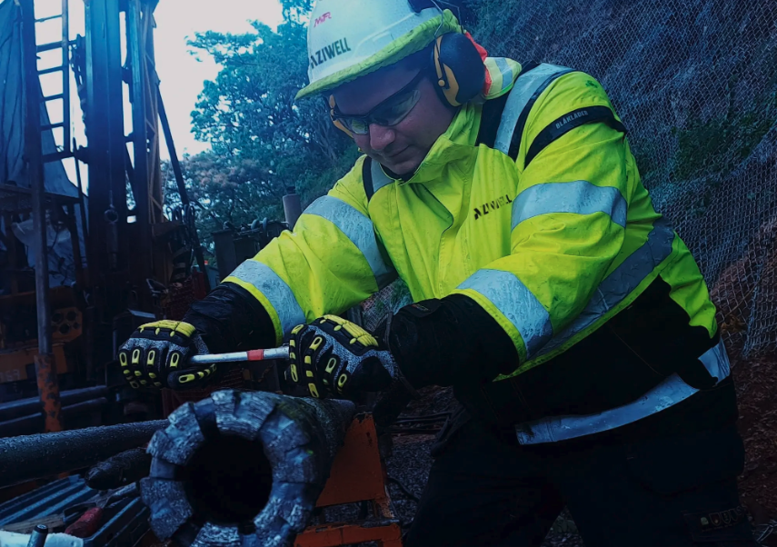 Operario utilizando equipos de perforación direccional con recuperación de núcleo (DCD) de Aziwell en el terreno. En primer plano se detalla la corona de perforación diamantina.