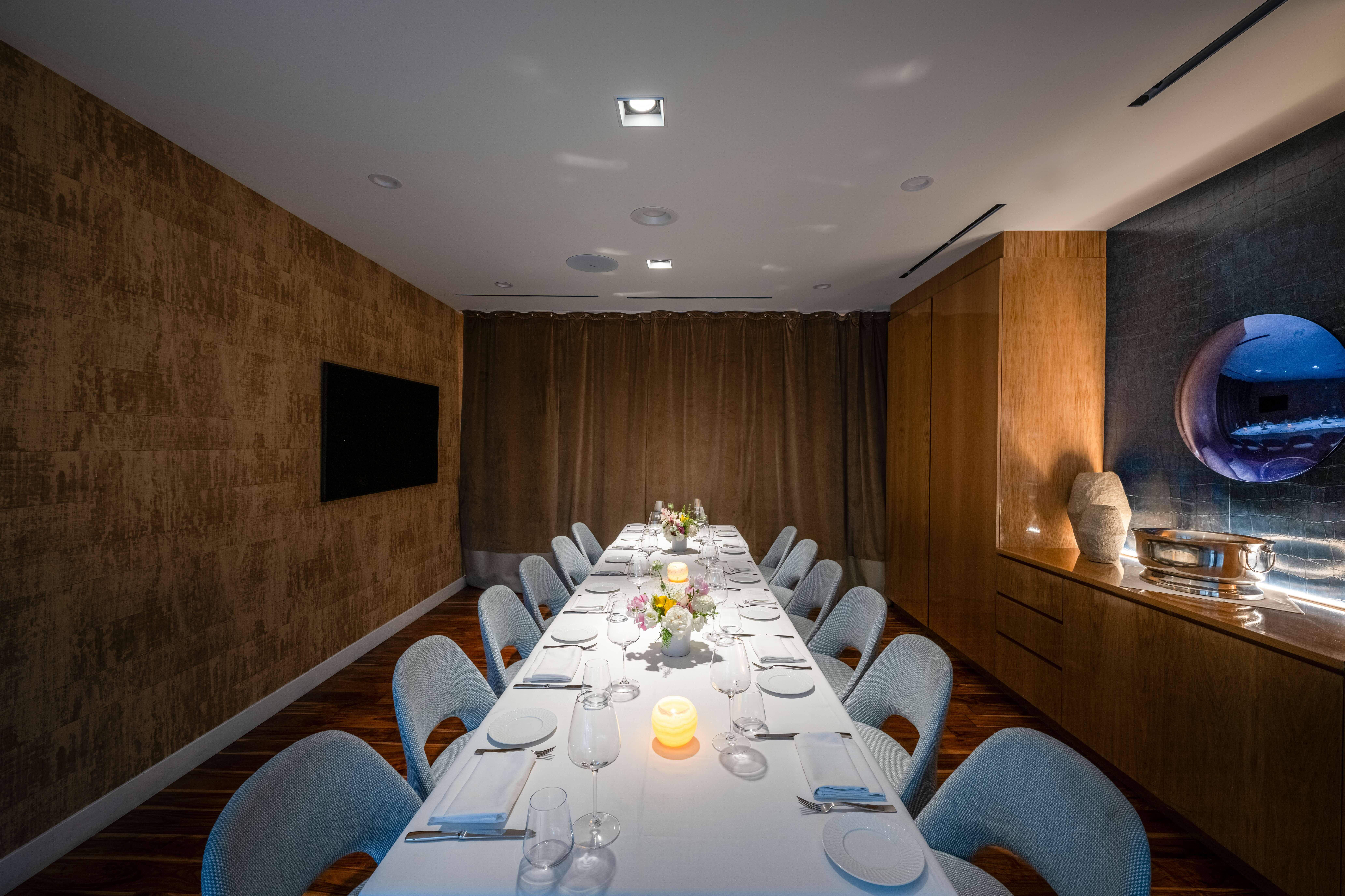 marea beverly hills' positano private dining room - a long table with white tablecloths leads to a large window