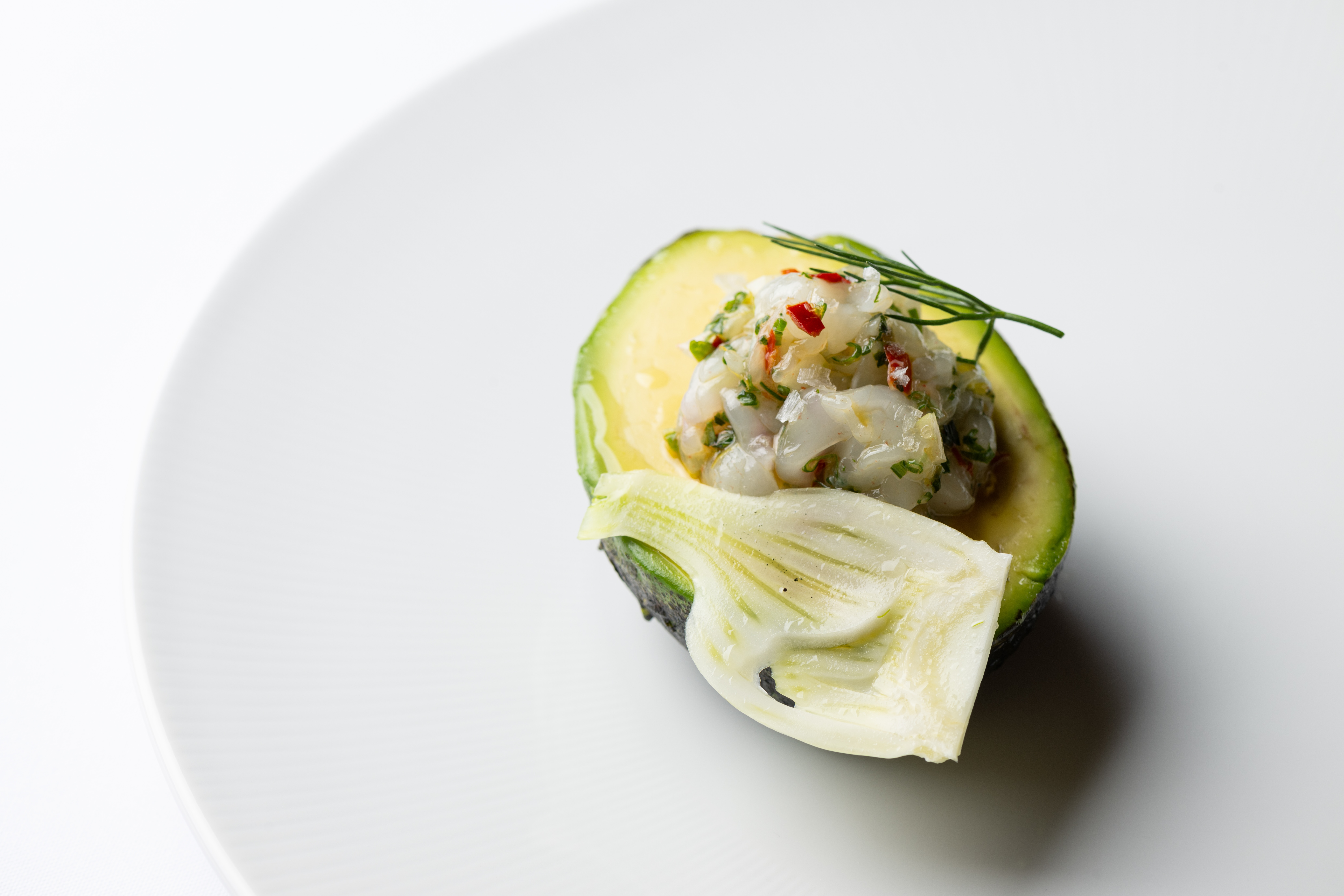 half an avocado, filled with spot prawn tartare