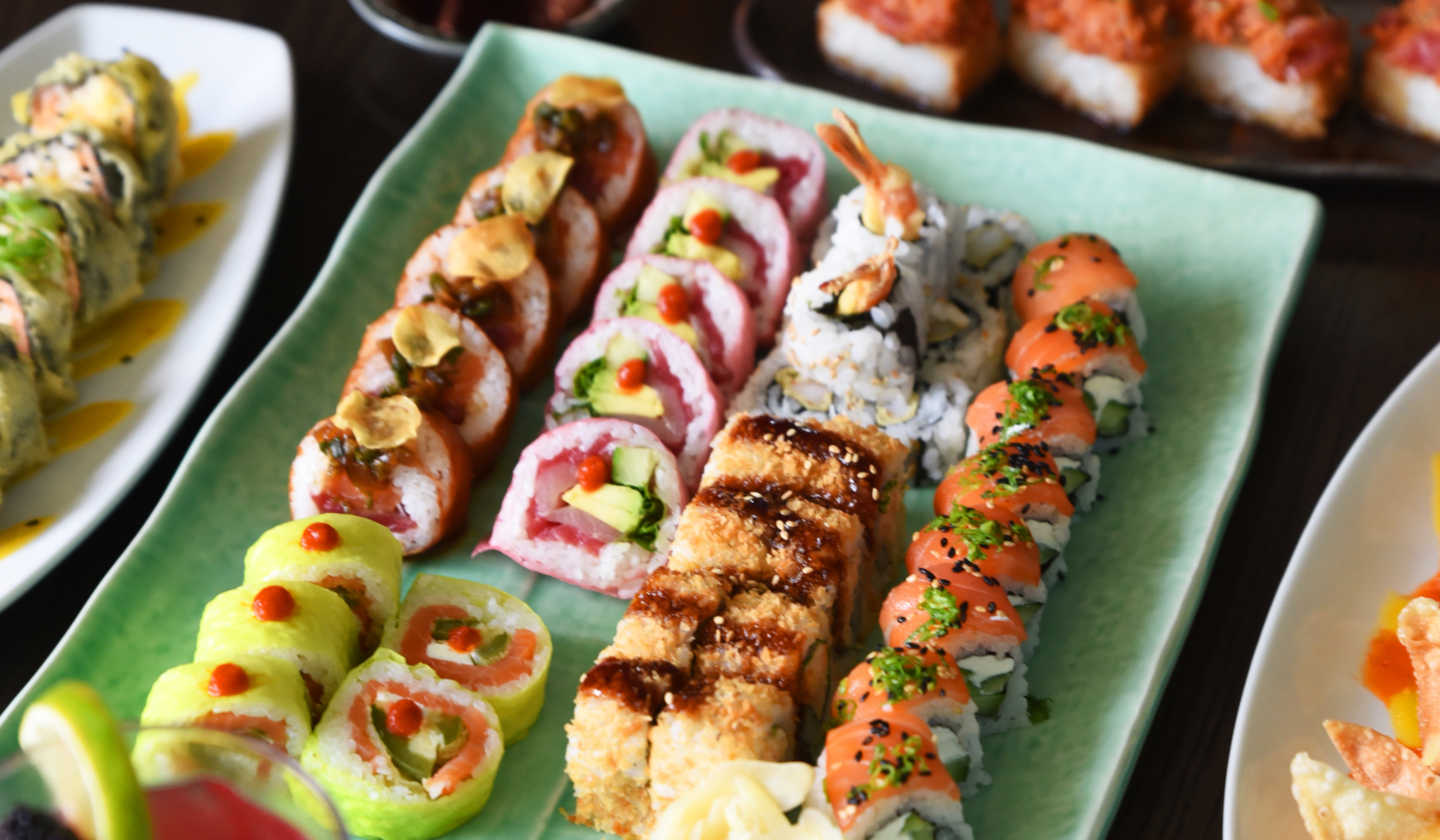 A vibrant sushi platter filled with an assortment of mouthwatering rolls and other appetizing dishes.