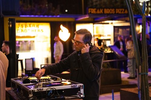 A DJ with headphones on playing music