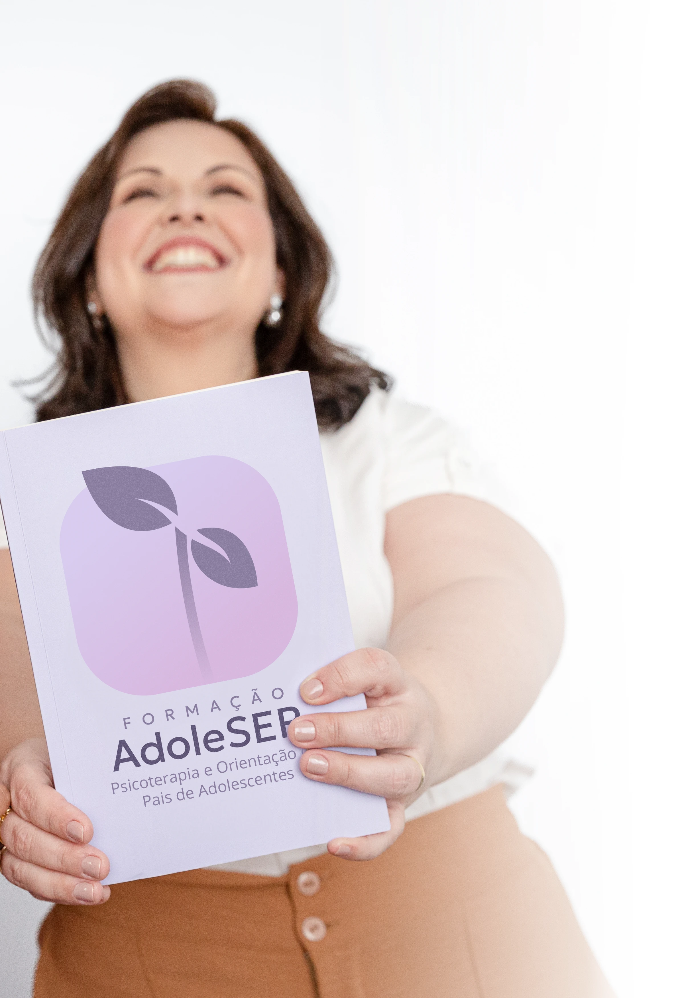 Pessoa segurando material da formação AdoleSER, extensão da Orientando Psis para psicoterapia e orientação de pais de adolescentes.
