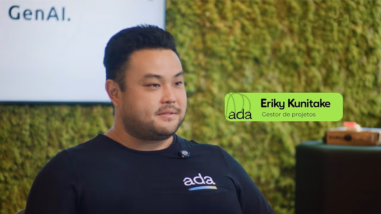 Eriky Kunitake, gestor de projetos da Ada, com camiseta preta e fundo verde musgo.