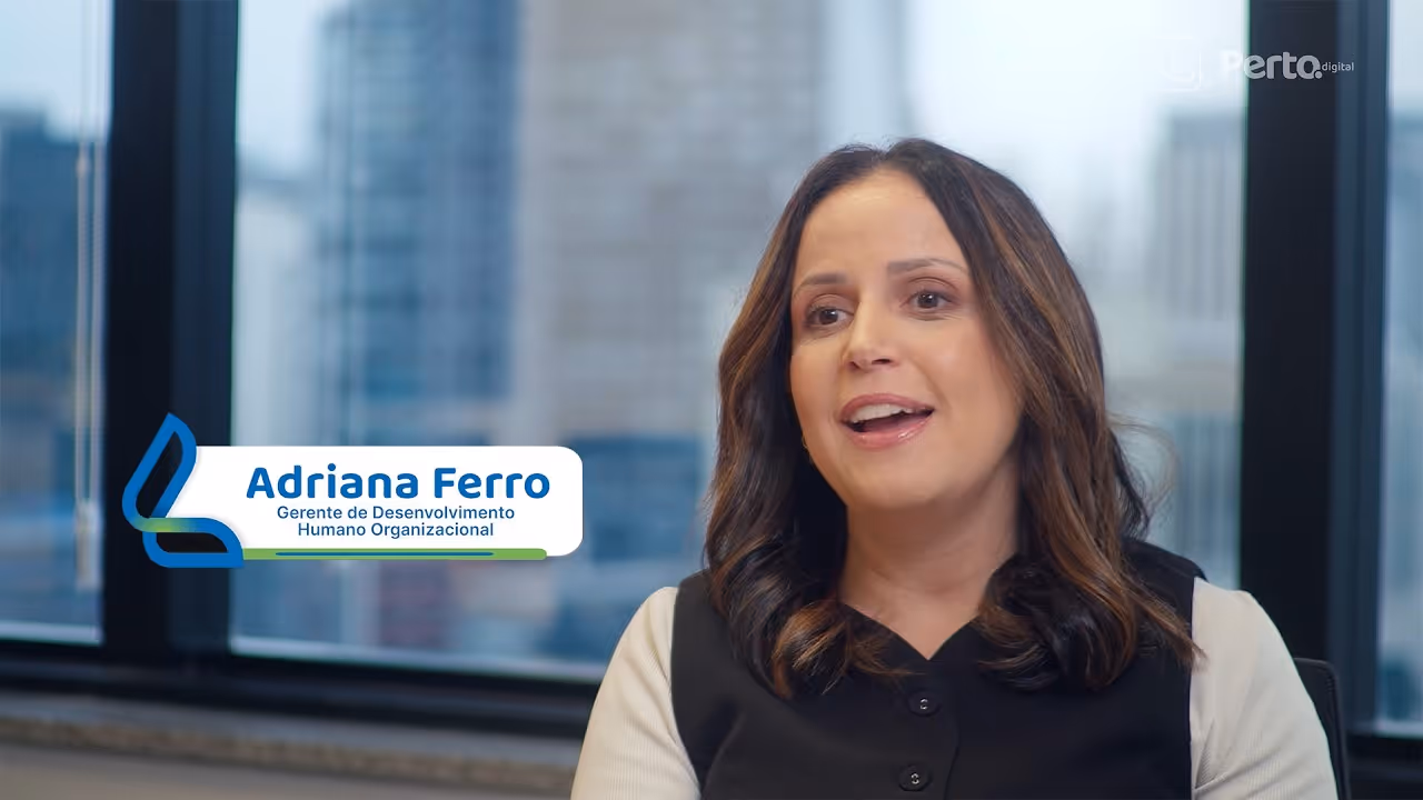 Júlia Bicaletto, Analista de Sustentabilidade, sorrindo em ambiente de escritório com logo Elo atrás.