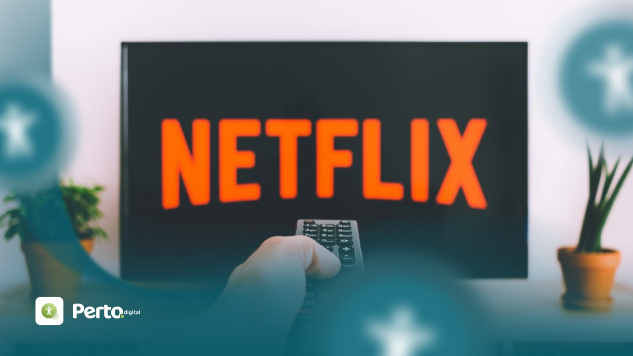 Mão segurando controle remoto em frente a uma TV exibindo o logotipo da Netflix, com planta em um vaso ao lado.