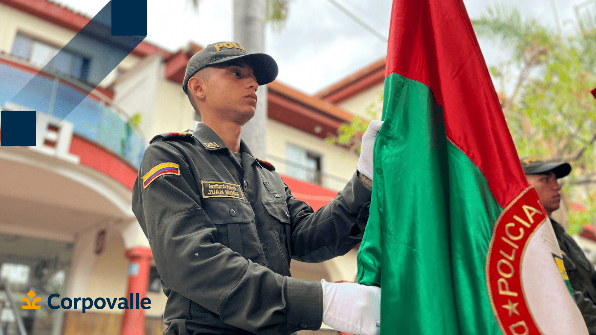 Un joven subteniente de la Policía Nacional sosteniendo una bandera, representando una ceremonia o evento oficial en la región.