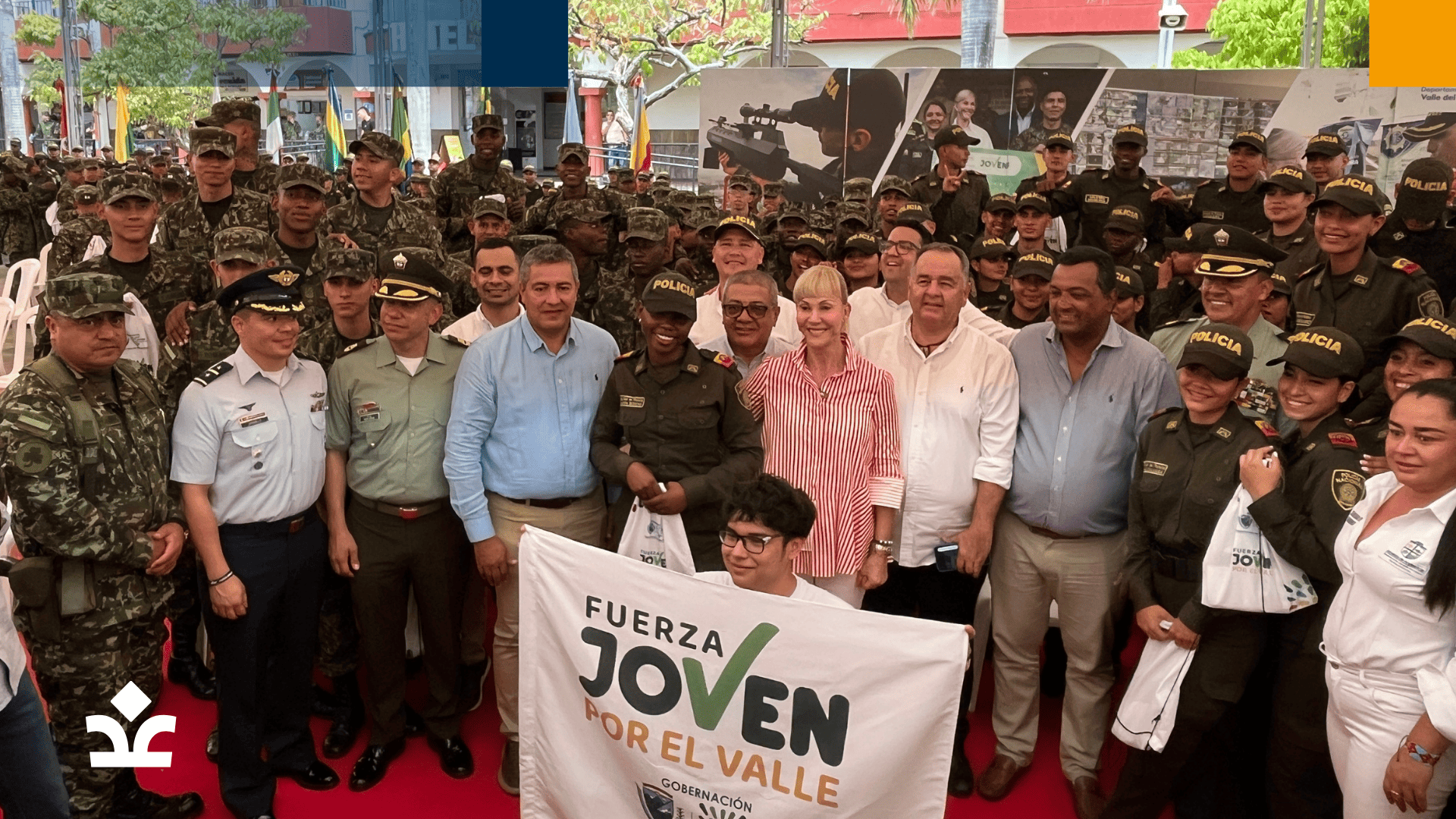 Un grupo de cadetes militares y oficiales de policía junto a representantes de Corpovalle, sosteniendo una pancarta que promueve un programa de apoyo a los jóvenes.
