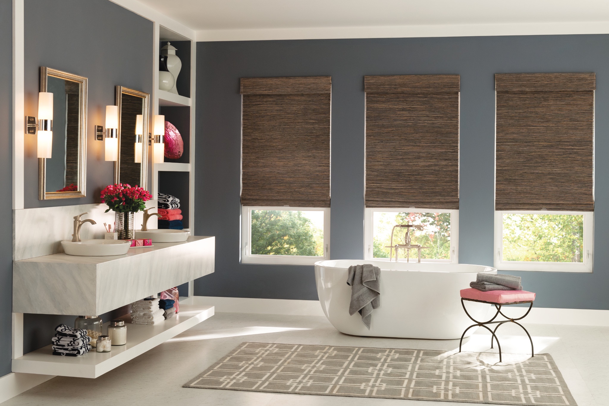Natural woven shades above a freestanding bathtub