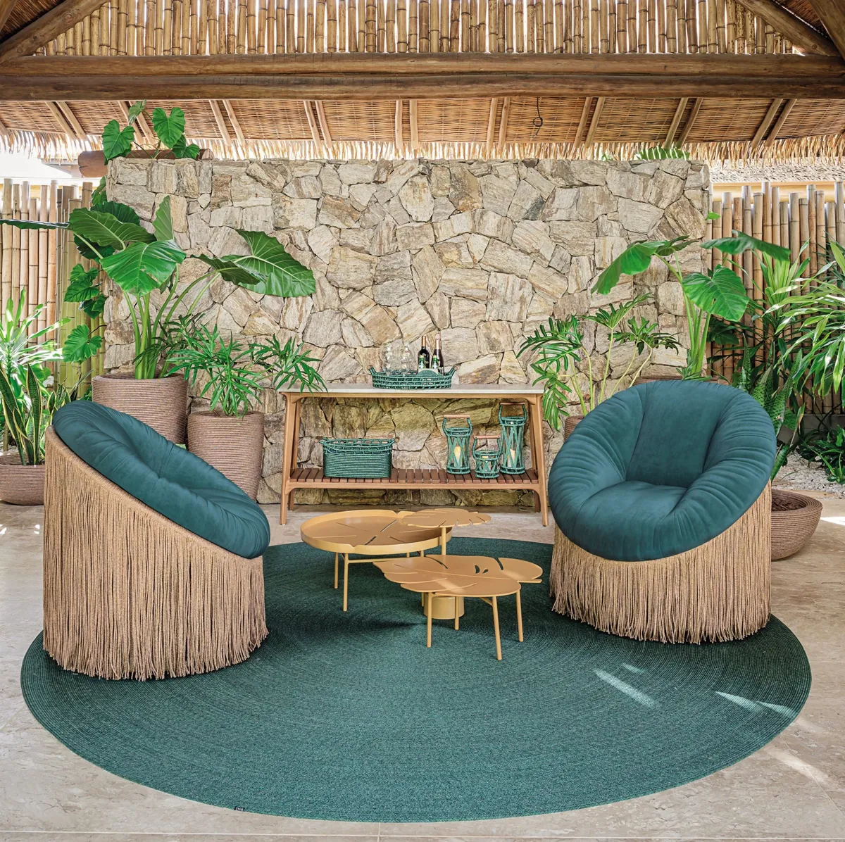 Tidelli Boho lounge chairs with deep green upholstery and fringed bases in a tropical outdoor lounge