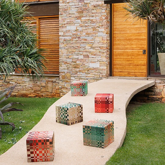 Colorful woven Tidelli Pentagramma ottomans on a curved garden terrace