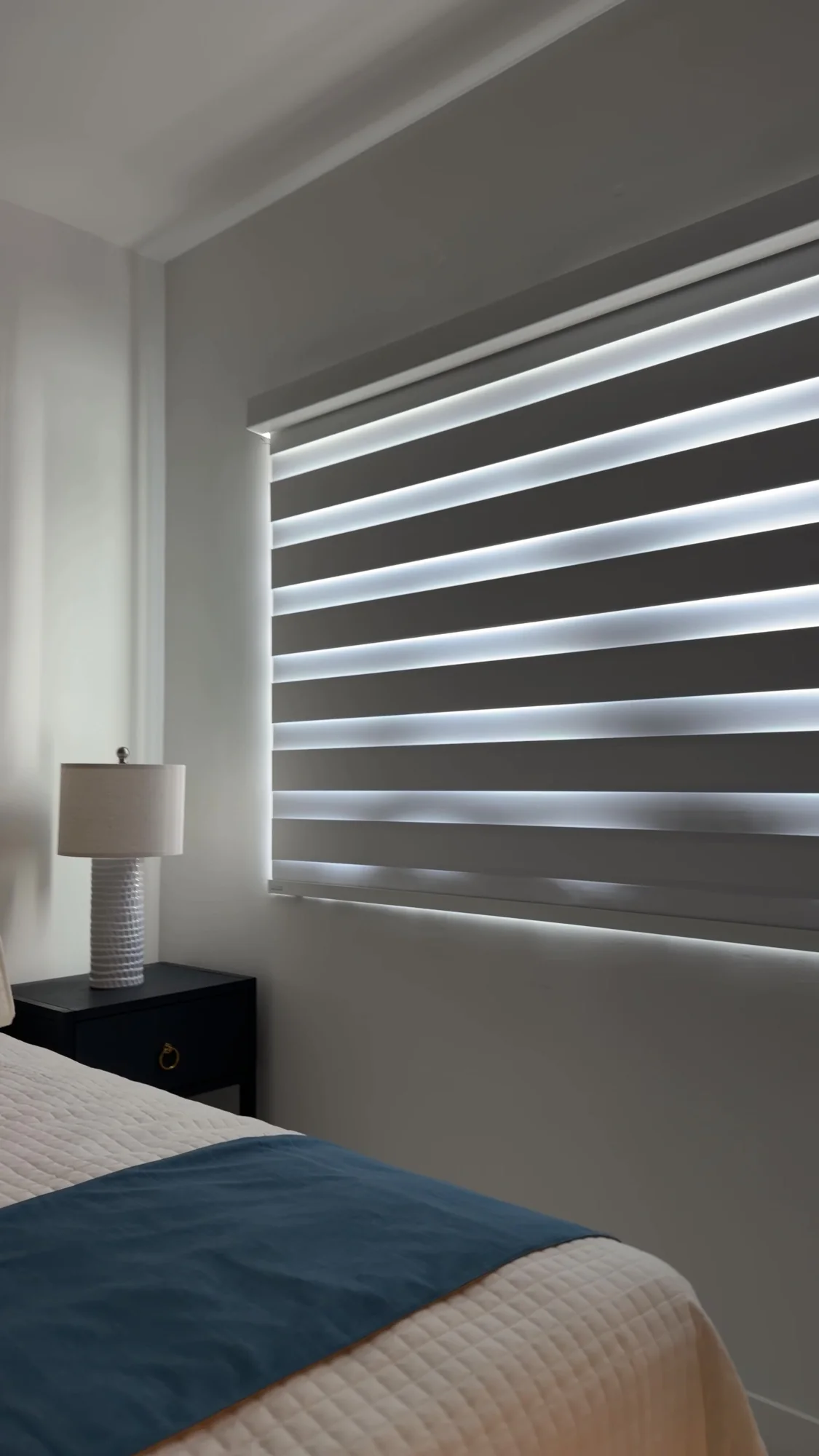 Alternating shade bands beside the blue bedroom furnishings.