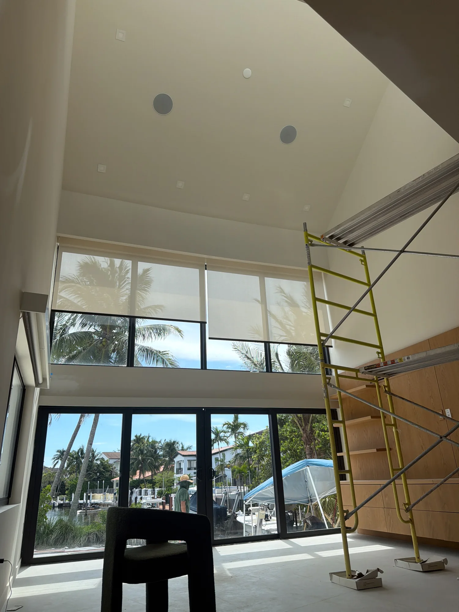 Double-height room shown during the shade installation.