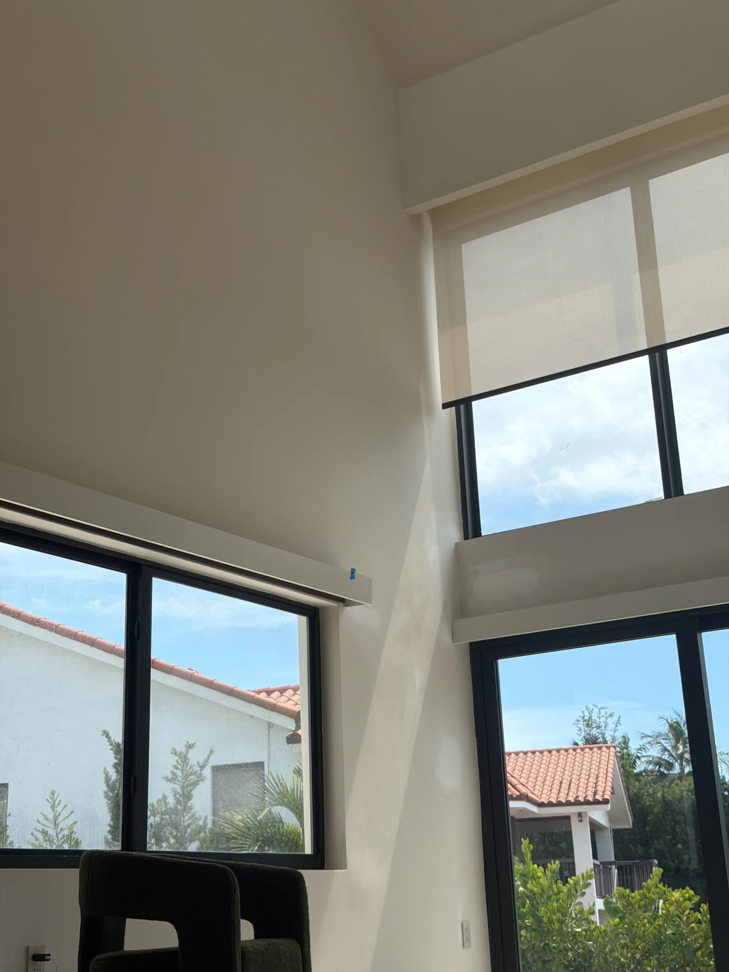 High-window roller shades during installation review.