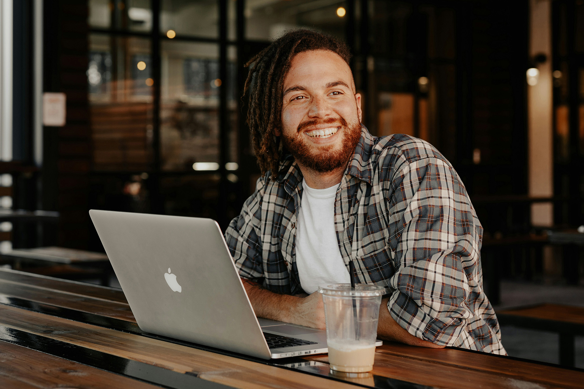 Man lachend achter zijn laptop bij AI cursus