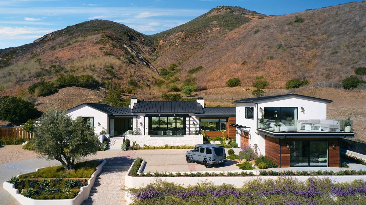 Single-story Malibu home on a hillside pad with the Santa Monica Mountains rising directly behind it