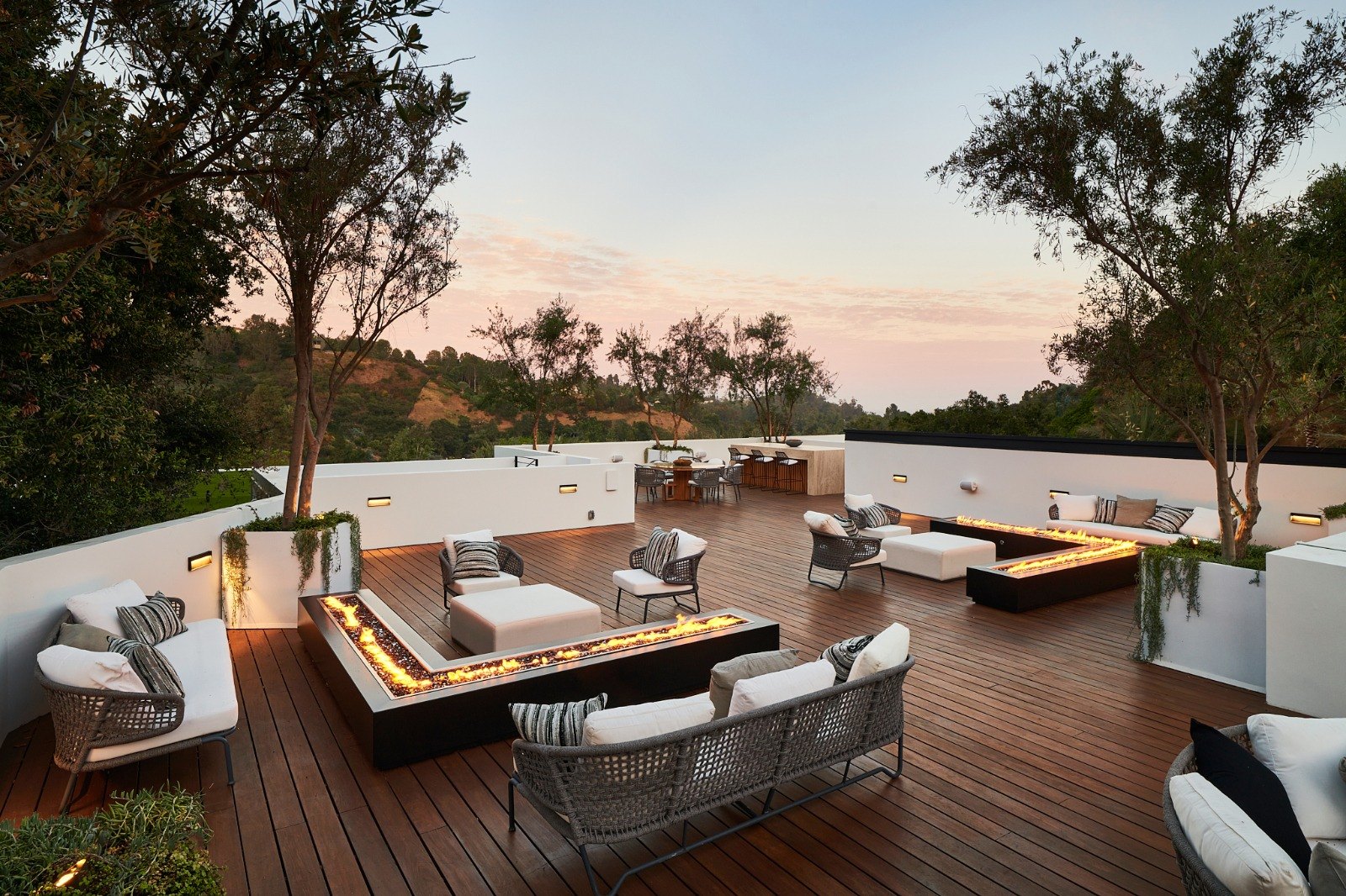 Roof deck of a Mandeville Canyon home at sunset, looking out over the wooded canyon and the hills beyond