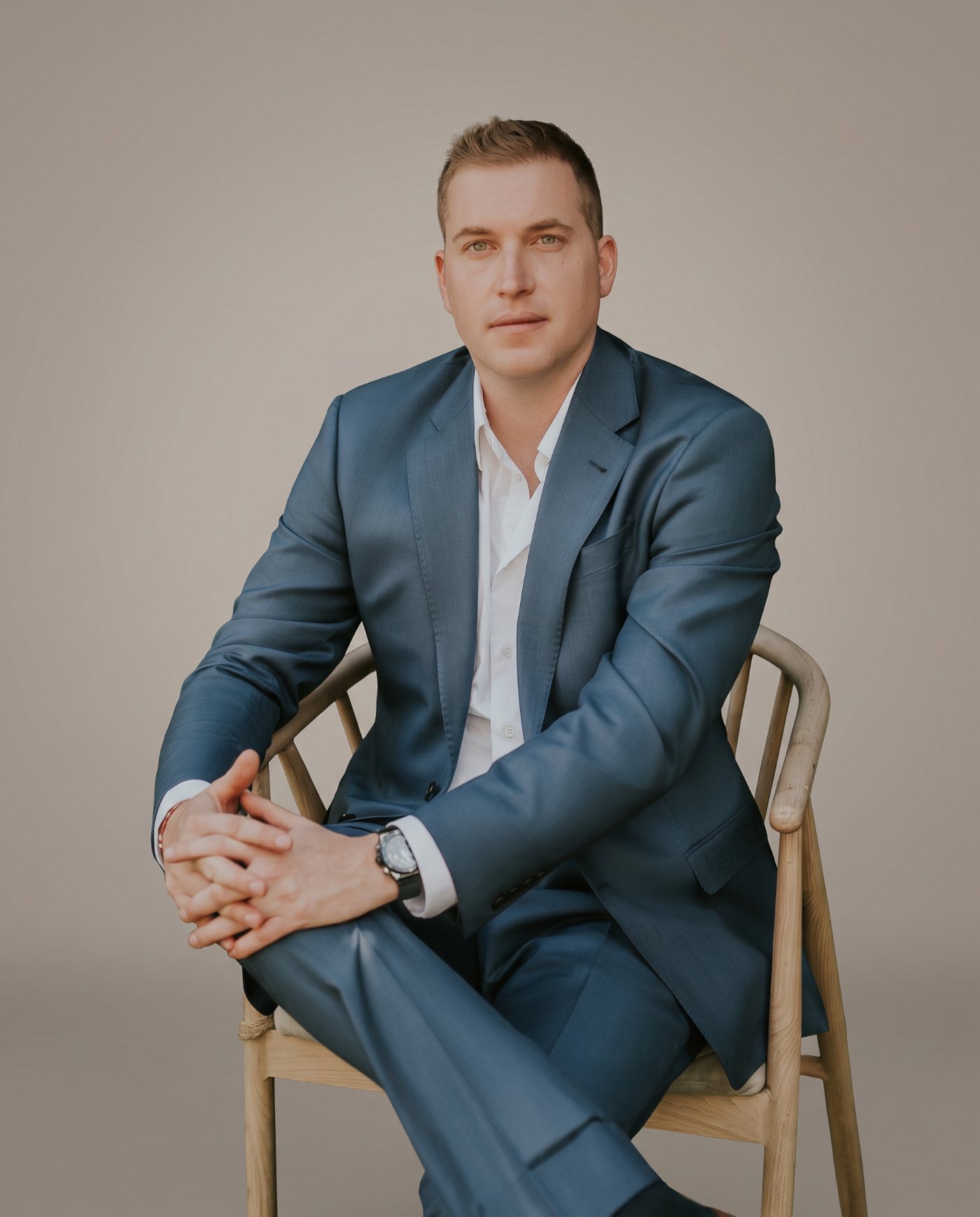 Alik Konovalenko, founder and owner of Energize Builders, seated in a studio portrait
