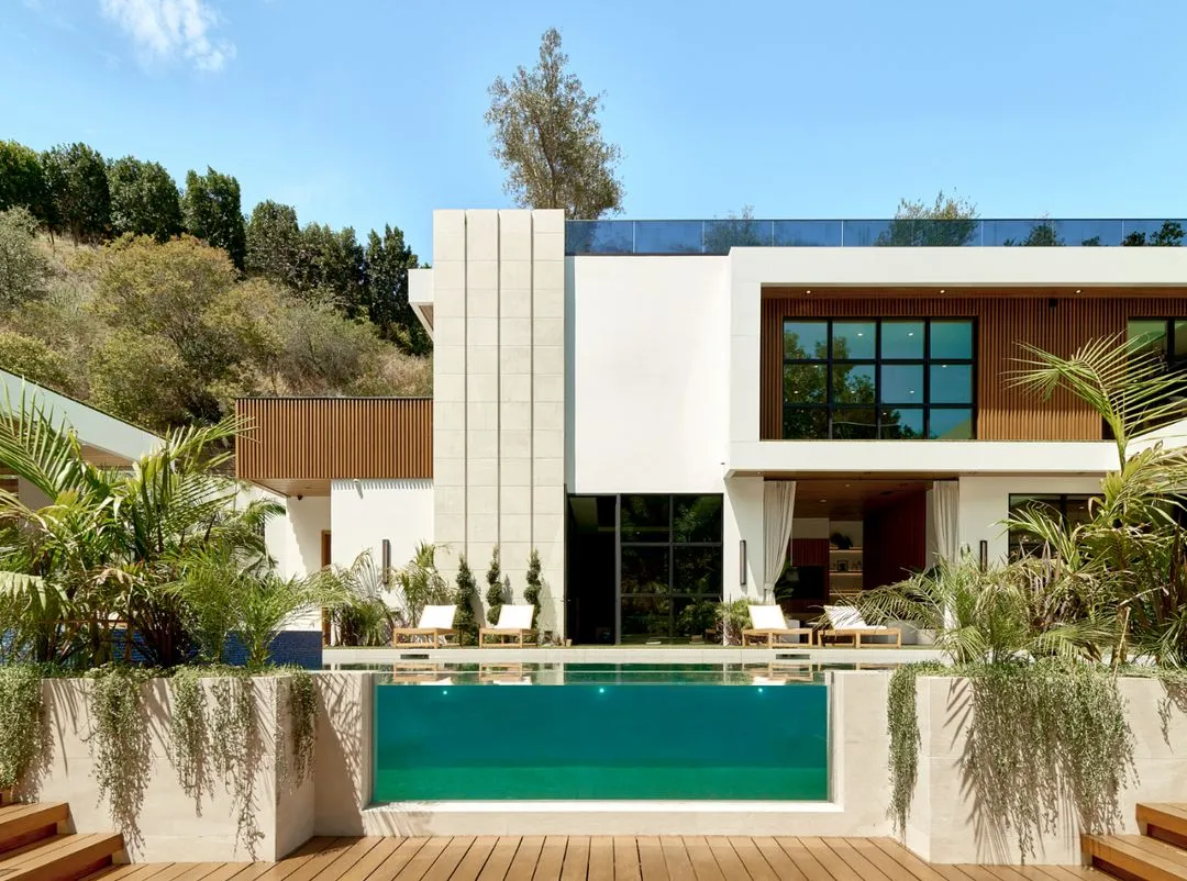 White modern home on Chalon Rd, Los Angeles, with a glass-edged pool and the hillside behind