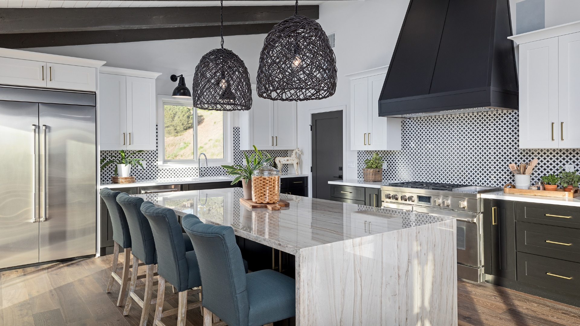 Modern kitchen remodeled in Malibu with black and white cabinetry and marble island
