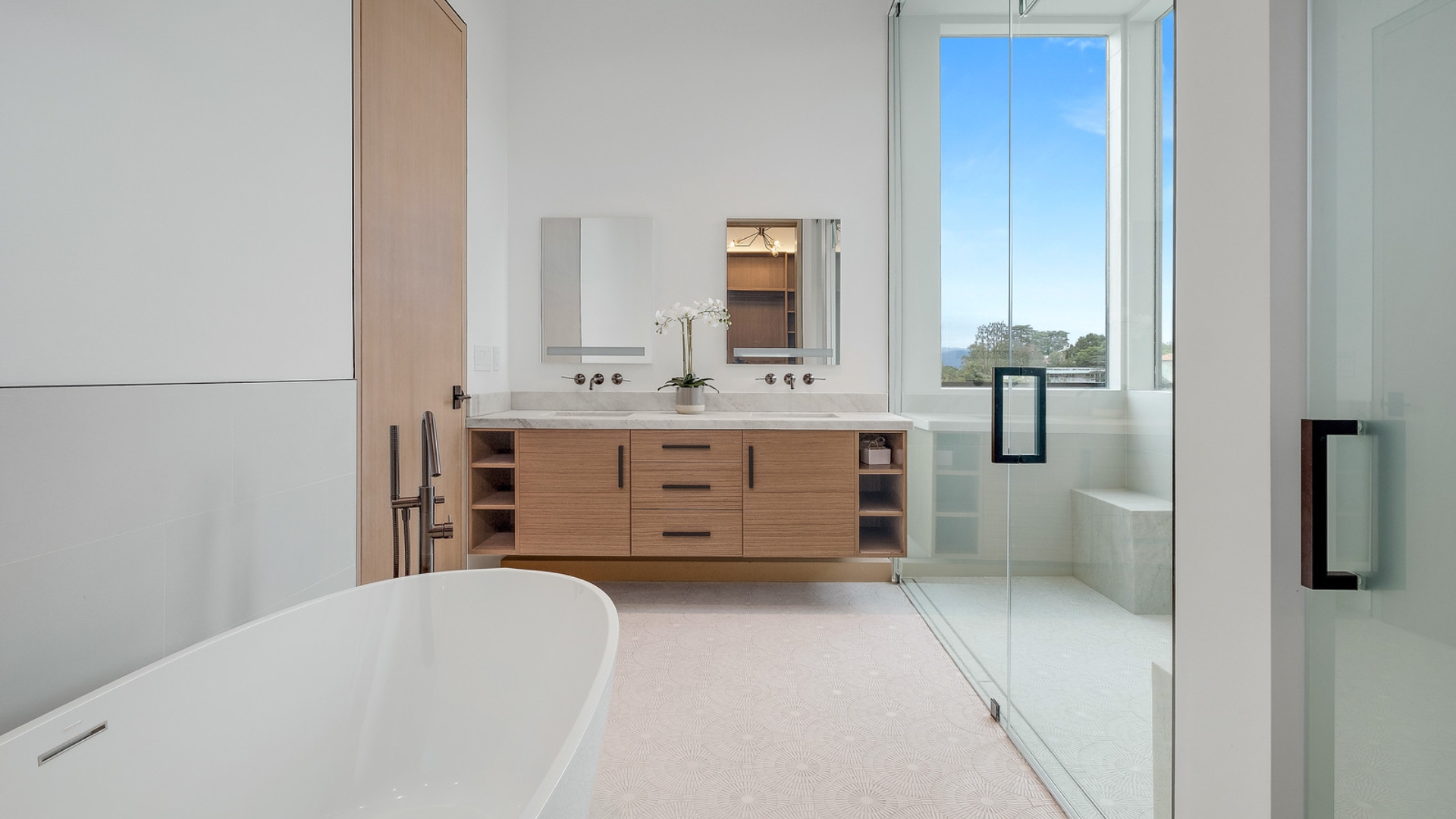 Modern Los Angeles bathroom with floating vanity, freestanding tub, sleek fixtures, and a glass shower enclosure.