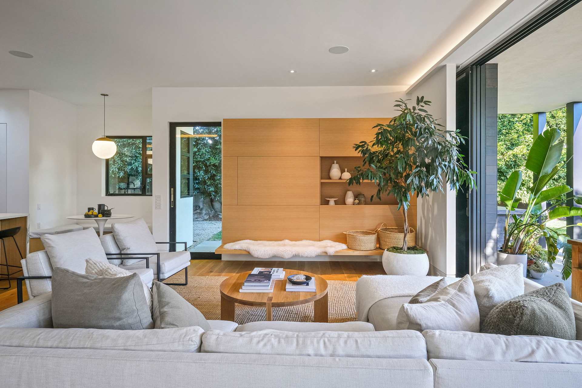 Bright modern living room interior with custom wood wall and open layout.