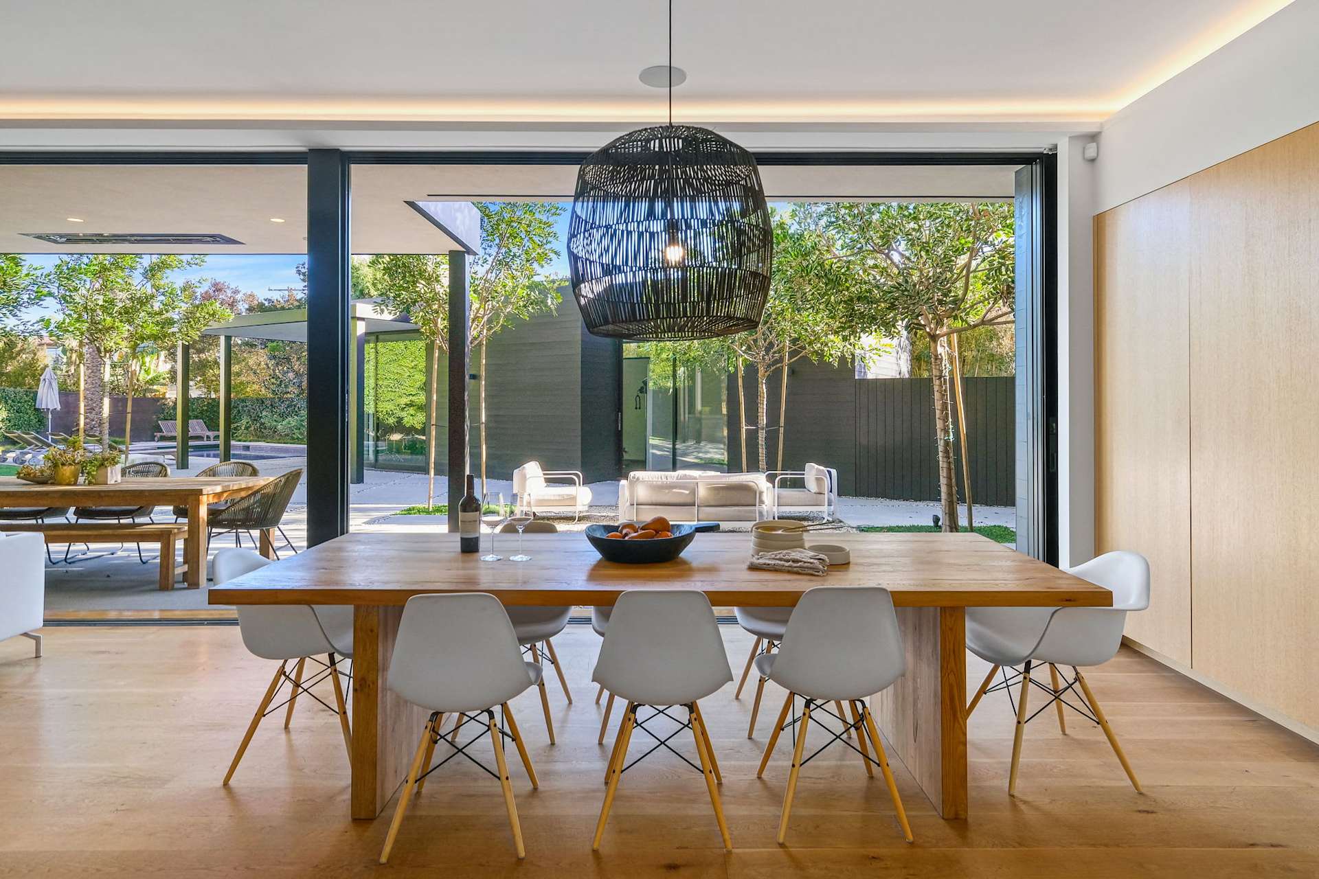 Modern dining room with large sliding glass doors and backyard view.