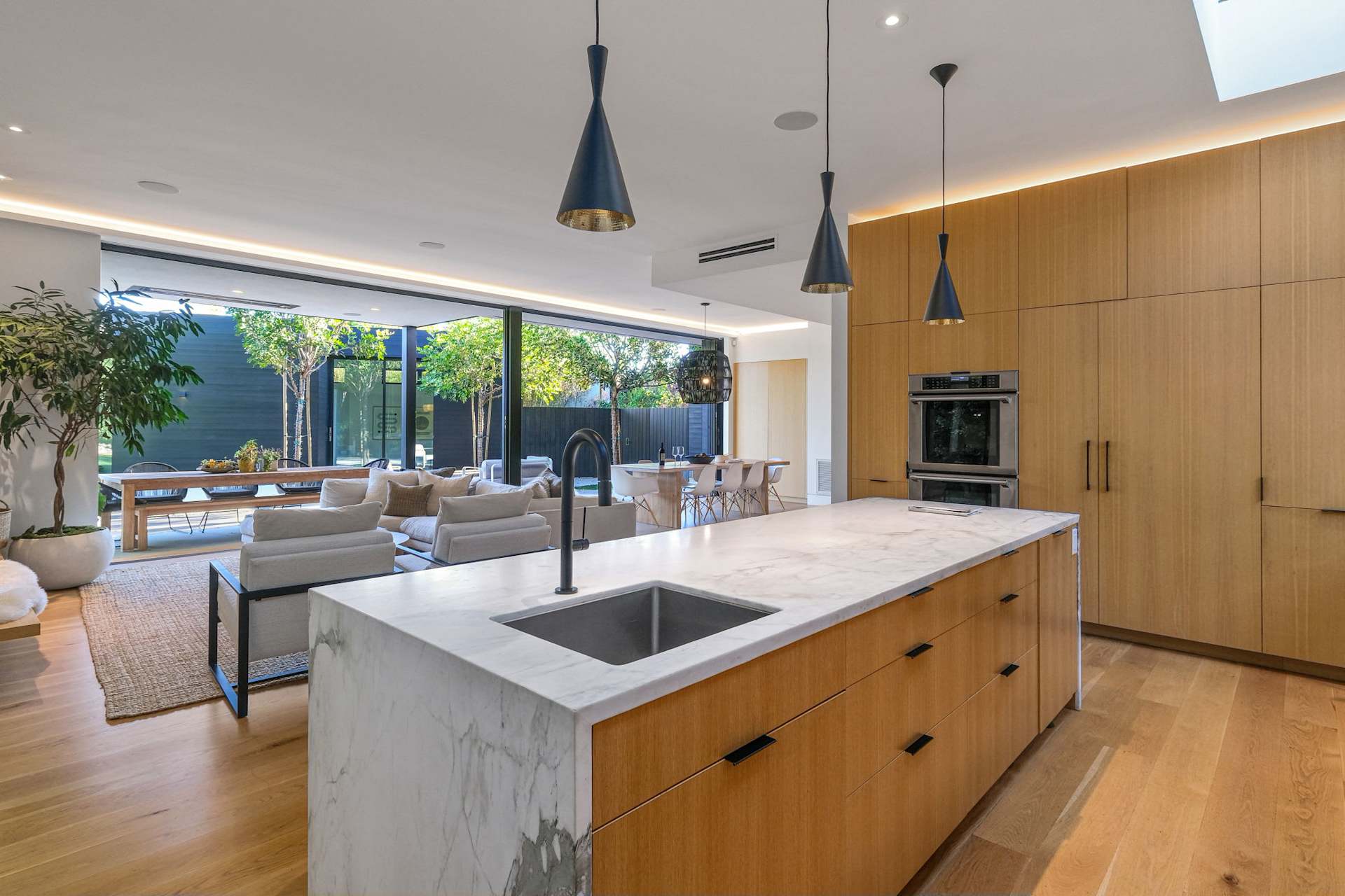 Open-concept kitchen with marble island and custom wood cabinetry.